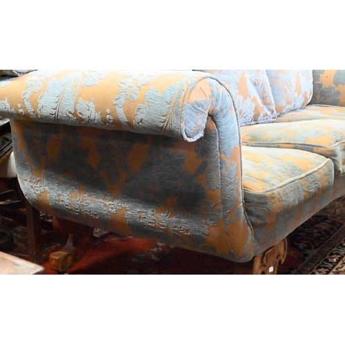 873 - An walnut and upholstered three-seat sofa with blue and brown/gold upholstery / cushions, raised on ... 