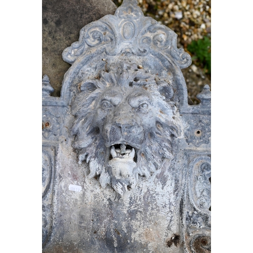 896 - An old weathered lead lion mask wall fountain with lion head spout over a half-round basin, 76 cm h