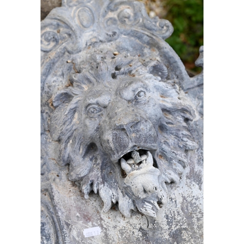 896 - An old weathered lead lion mask wall fountain with lion head spout over a half-round basin, 76 cm h