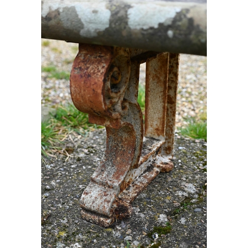 897 - A weathered antique stone and cast iron garden bench, the rectangular seat raised on three decorativ... 