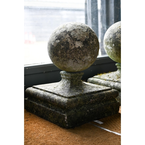 899 - A pair of large weathered old cast stone spherical finials, raised on square socle bases, 40 cm x 40... 