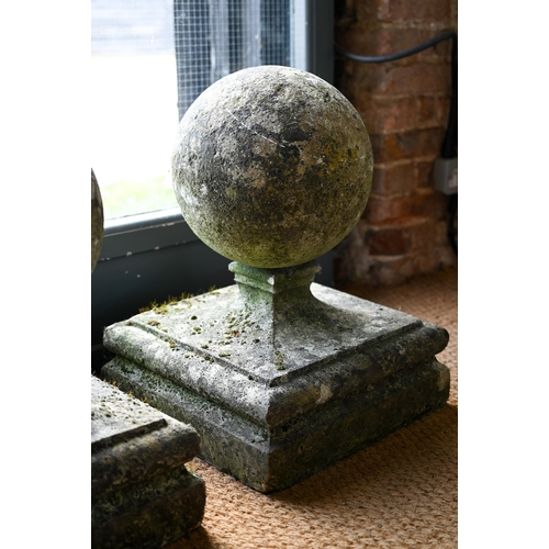 899 - A pair of large weathered old cast stone spherical finials, raised on square socle bases, 40 cm x 40... 