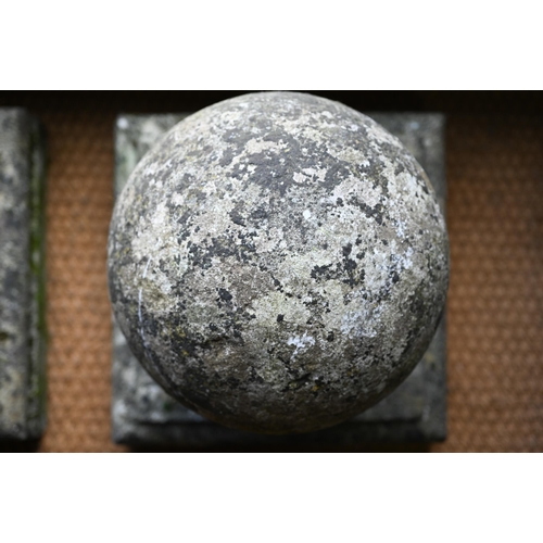 899 - A pair of large weathered old cast stone spherical finials, raised on square socle bases, 40 cm x 40... 