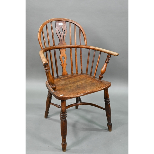 918 - An old Windsor elbow chair with elm seat and raised over a crinoline stretcher