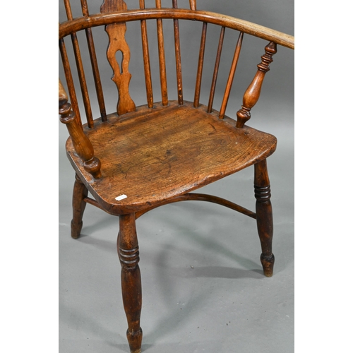 918 - An old Windsor elbow chair with elm seat and raised over a crinoline stretcher