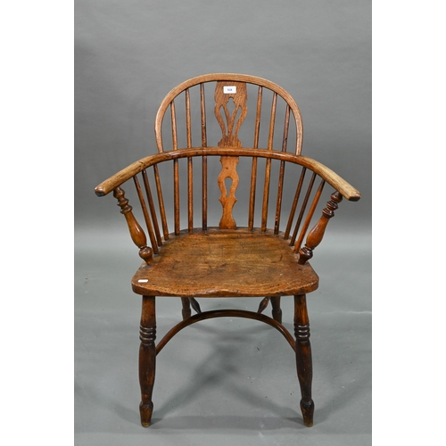 918 - An old Windsor elbow chair with elm seat and raised over a crinoline stretcher