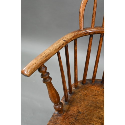 918 - An old Windsor elbow chair with elm seat and raised over a crinoline stretcher