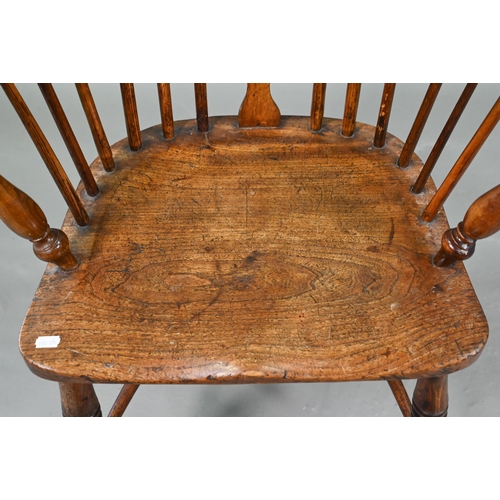 918 - An old Windsor elbow chair with elm seat and raised over a crinoline stretcher