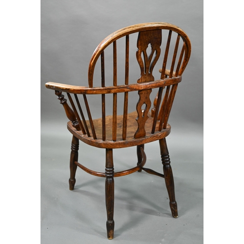 918 - An old Windsor elbow chair with elm seat and raised over a crinoline stretcher