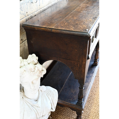 925 - An antique oak low dresser with three double moulded front drawers over a triple arched apron, raise... 