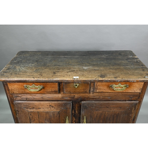 928 - An antique provincial French oak cupboard, Normandy, with three drawers over a pair of mitre framed ... 