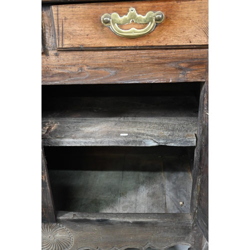 928 - An antique provincial French oak cupboard, Normandy, with three drawers over a pair of mitre framed ... 