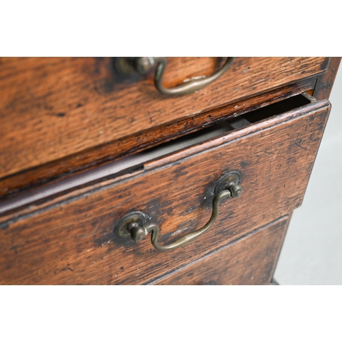 929 - An 18th century oak chest, the wavy frieze over a centre cupboard flanked by short two tier drawers,... 