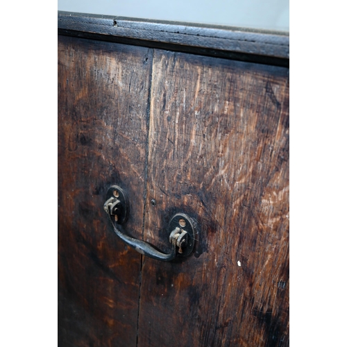 929 - An 18th century oak chest, the wavy frieze over a centre cupboard flanked by short two tier drawers,... 