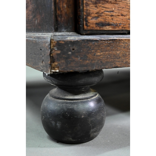 929 - An 18th century oak chest, the wavy frieze over a centre cupboard flanked by short two tier drawers,... 