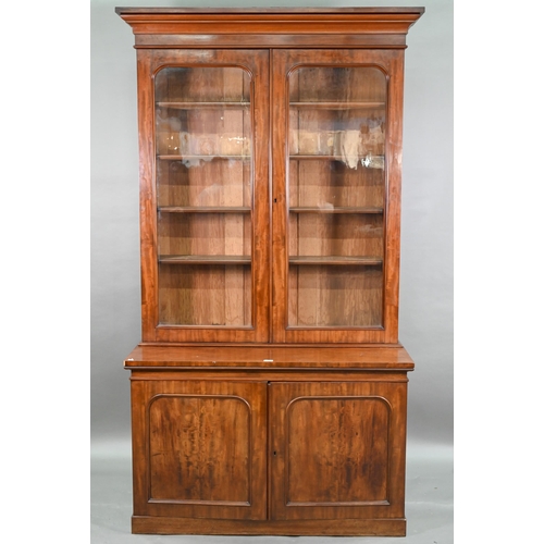 933 - A late Victorian mahogany library cabinet bookcase, the pair of arched glazed doors over a conformin... 