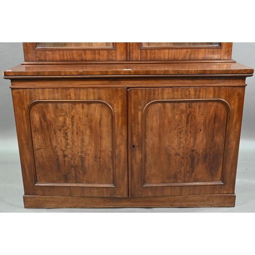 933 - A late Victorian mahogany library cabinet bookcase, the pair of arched glazed doors over a conformin... 