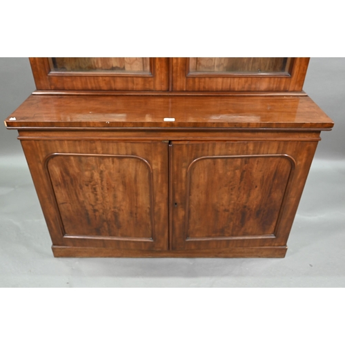 933 - A late Victorian mahogany library cabinet bookcase, the pair of arched glazed doors over a conformin... 