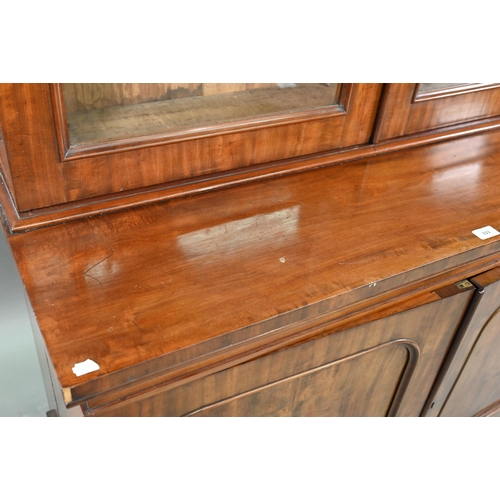 933 - A late Victorian mahogany library cabinet bookcase, the pair of arched glazed doors over a conformin... 