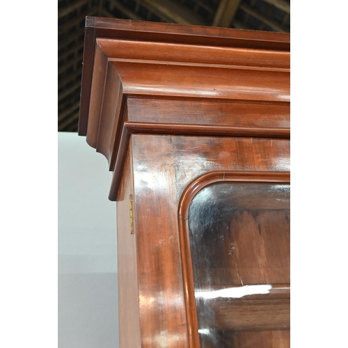 933 - A late Victorian mahogany library cabinet bookcase, the pair of arched glazed doors over a conformin... 