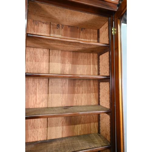 933 - A late Victorian mahogany library cabinet bookcase, the pair of arched glazed doors over a conformin... 