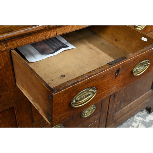 945 - An 18th century and later oak high dresser, the three tier rack with plank back over an arrangement ... 