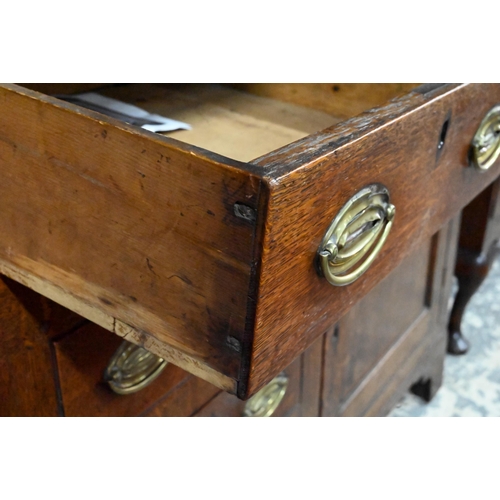 945 - An 18th century and later oak high dresser, the three tier rack with plank back over an arrangement ... 