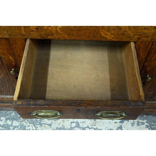 945 - An 18th century and later oak high dresser, the three tier rack with plank back over an arrangement ... 