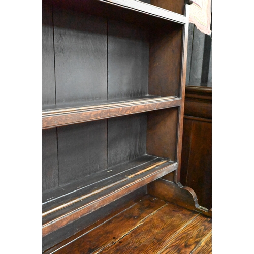 945 - An 18th century and later oak high dresser, the three tier rack with plank back over an arrangement ... 