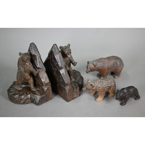 1164 - A pair of Black Forest carved bear book-ends, to/w a matched graduated set of three bears