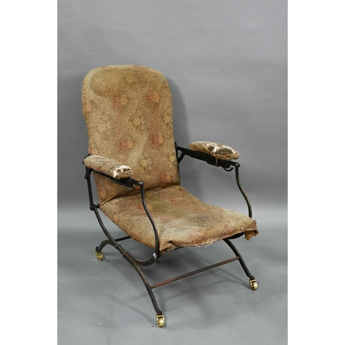 927 - A Victorian folding iron-framed campaign armchair with remnants of original upholstery fabric, the f... 