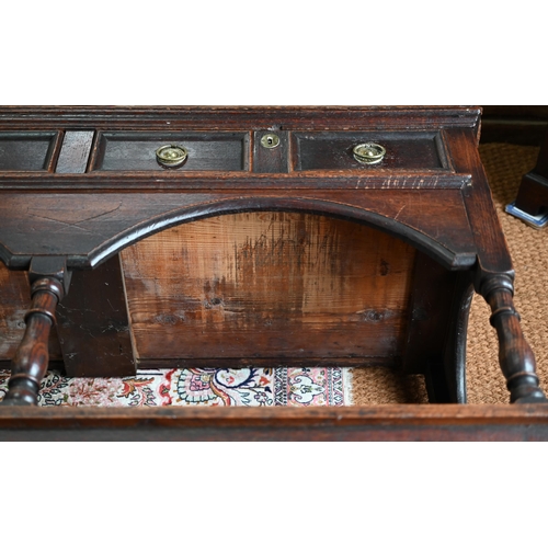 925 - An antique oak low dresser with three double moulded front drawers over a triple arched apron, raise... 