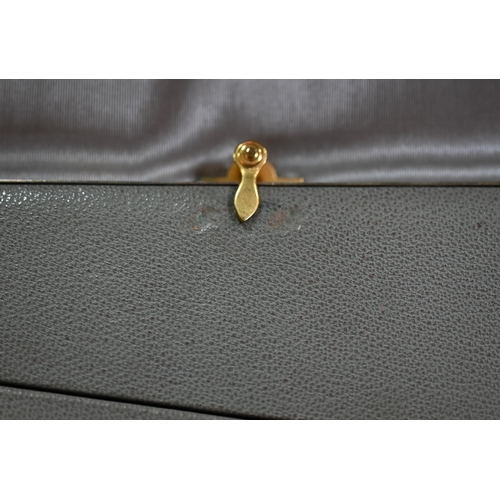 136 - A vintage grey leather dressing-case by Finnigan's of Bond Street, the watered grey satin lining wit... 