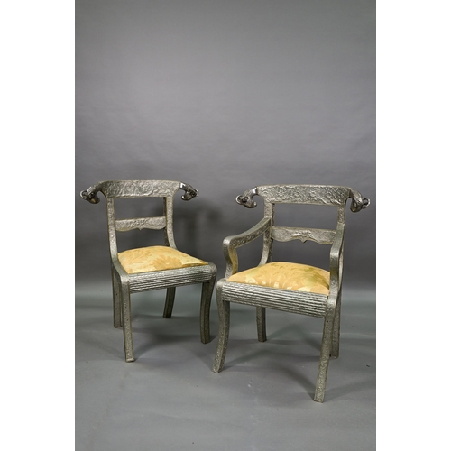 103 - A pair of Indian metal clad dining hall chairs, with rams head back terminals over sabre front legs ... 