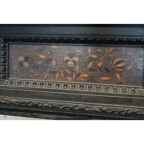 136 - An antique carved oak fire surround with iron masks and foliate marquetry panels, 104 cm high x 100 ... 