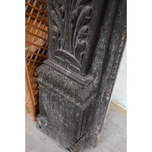 136 - An antique carved oak fire surround with iron masks and foliate marquetry panels, 104 cm high x 100 ... 