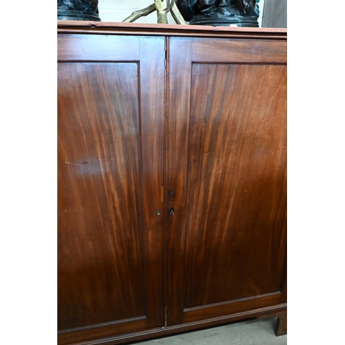 138 - A 19th century mahogany linen press with panelled doors enclosing five slides standing on bracket fe... 