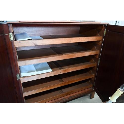 138 - A 19th century mahogany linen press with panelled doors enclosing five slides standing on bracket fe... 