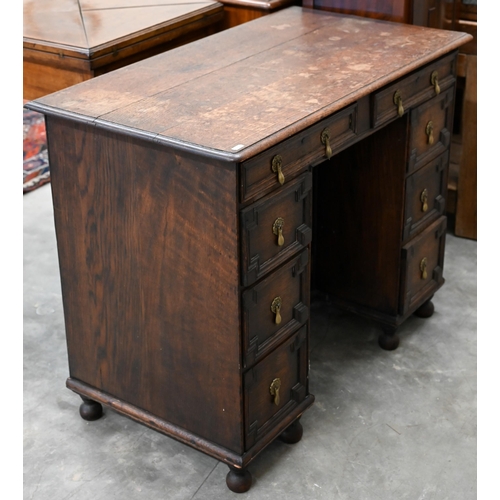 141 - A 19th century Jacobean style oak kneehole desk with eight drawers around the central recessed cupbo... 