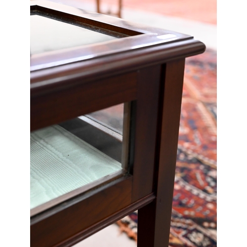 143 - A mahogany veneered and glazed vitrine display cabinet with hinged top and tapering square supports,... 