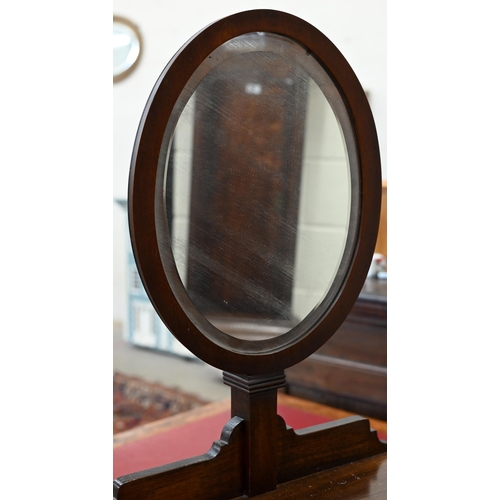 145 - A mahogany vanity stand with adjustable oval mirror, drawer and cupboard on tapering square supports... 