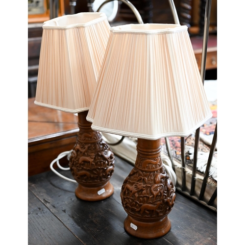 161 - A pair of Indian carved table lamps with shades to/w Indian cane and hardwood magazine/newspaper rac... 