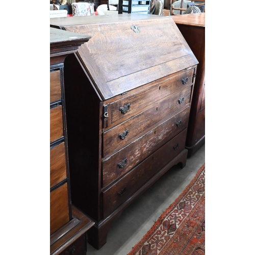 180 - A George III oak fall front bureau with fitted interior over four long graduating drawers on bracket... 