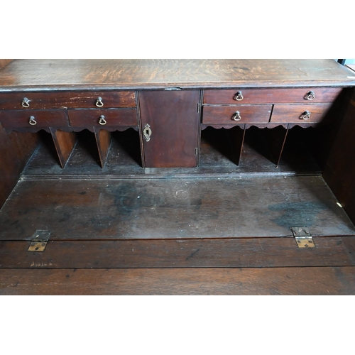 180 - A George III oak fall front bureau with fitted interior over four long graduating drawers on bracket... 