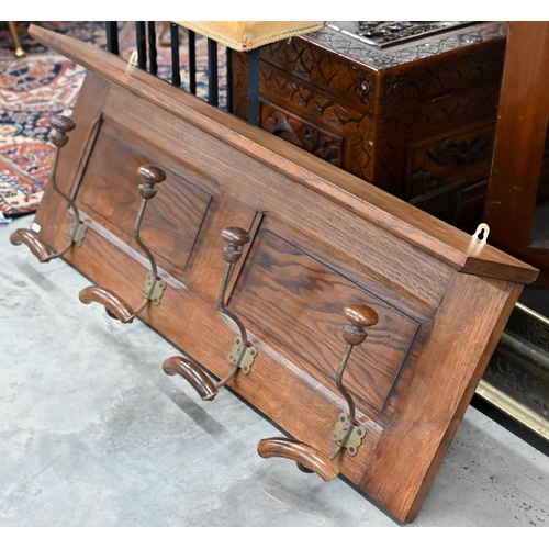 197 - A panelled oak hall shelf with four wrought iron hat/coat hooks, 100 cm wide x 40 cm high to/w a par... 