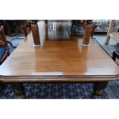 216 - A Victorian mahogany wind-out extending dining table with two leaves, raised on turned and fluted le... 