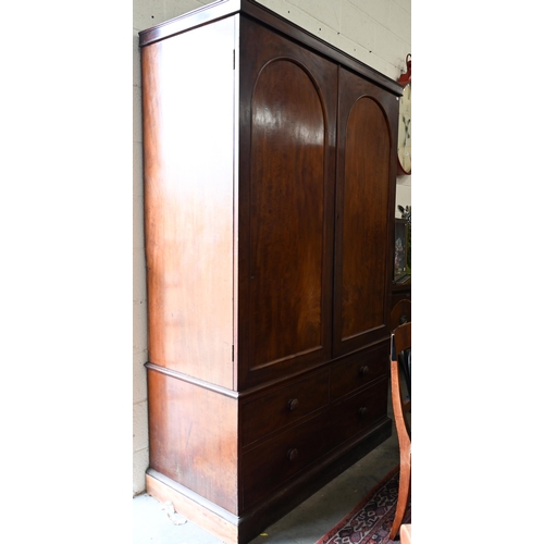 236 - A 19th century mahogany compactum wardrobe, arch panelled doors enclosing hanging space and slides o... 