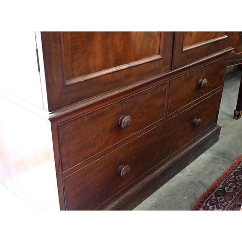 236 - A 19th century mahogany compactum wardrobe, arch panelled doors enclosing hanging space and slides o... 