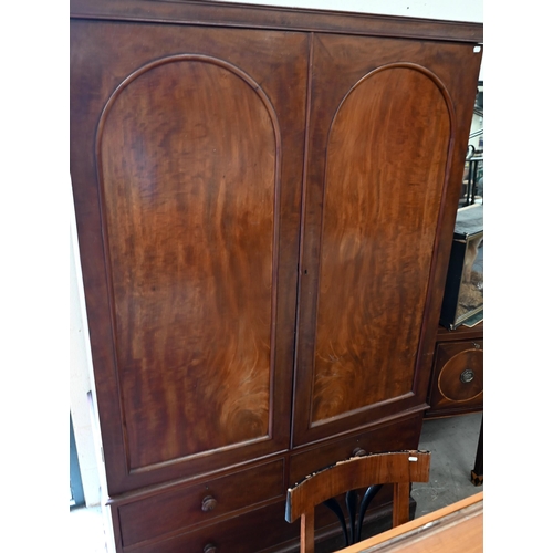 236 - A 19th century mahogany compactum wardrobe, arch panelled doors enclosing hanging space and slides o... 