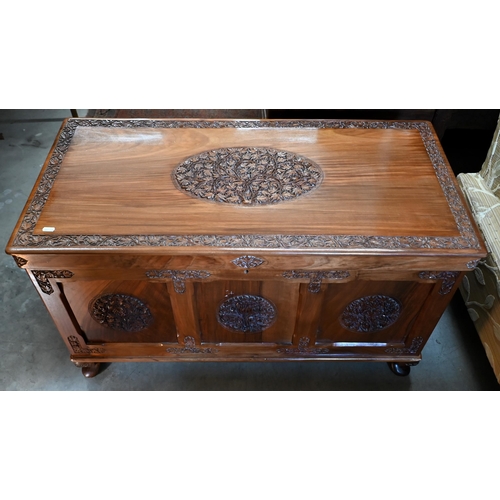 240 - An Indian hardwood blanket chest, panelled construction with foliate caned medallions and borders, s... 